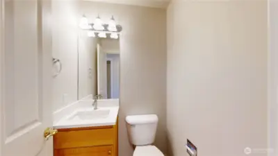 Clean and functional powder room featuring a single-sink vanity with updated quartz countertop, sleek faucet, and a large framed mirror.