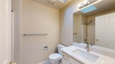 Updated hall bathroom, complete with a sleek quartz countertop vanity, and modern fixtures.