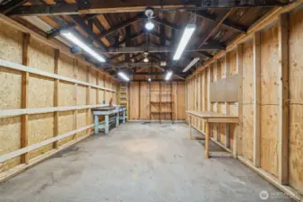 Garage with plenty of lighting and work benches.