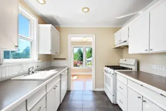 The kitchen has a tiled backsplash and flooring. The gas stove is only 6 months old.