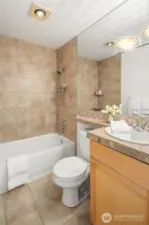 Featuring a marble vanity and elegant tiled accents, the shared bathroom also includes updated shower knobs and a brand-new medicine cabinet.