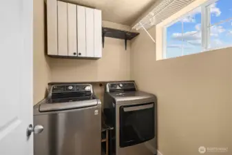 Upstairs laundry is conveniently located near all bedrooms and features extra built-in cabinetry for added storage and ease.
