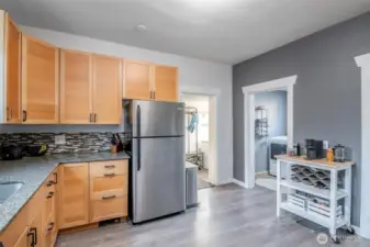 The kitchen has easy access to the back mud room and out to the backyard for a bar b que.