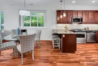 The dining area is quite large. While staging shows a round table, it can accommodate a 6-8 top rectangular table placed parallel to the window. New drum pendant and island lights.
