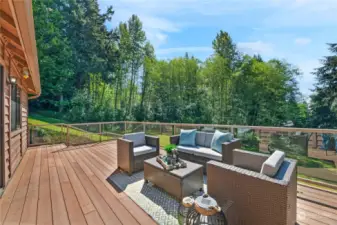 This spacious Trex deck, surrounded by the  breathtaking beauty of nature, features glass  panels to shield you from breezes while  opening up the view! This is a place of  respite. Watch the trees move with the wind.  See the sky above you. Refill your emotional  well as this is like being at a resort!
