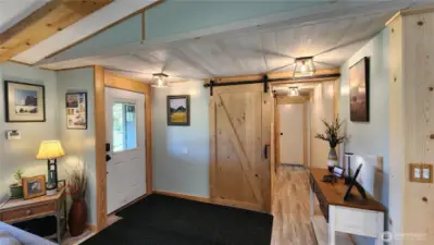 The warm entrance area leads to a hallway that extends toward the primary suite.