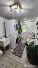 Renovated laundry/utility room with shiplap, new flooring and light fixtures.