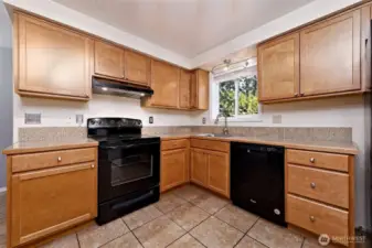 Such a nice modern kitchen with tile counters and floor!