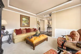 Enhanced with rich crown molding and  stunning coffered ceilings this formal living  room has an abundance of natural light.