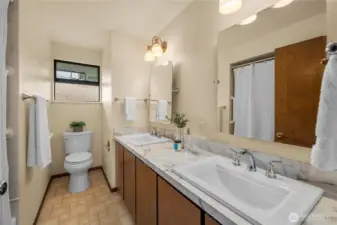 Main bathroom with shower/tub combo and dual sinks.