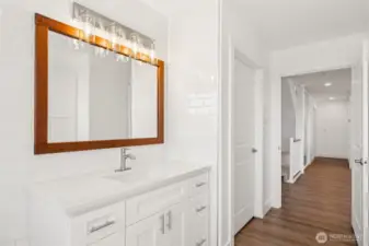 Those beautiful finishes including subway tile to the ceiling and quartz countertops follow through the guest bath on the main living level.