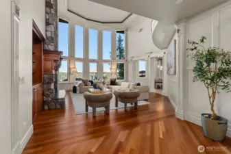 The grand entry continues into the great room with floor to ceiling windows allowing the outside, in.