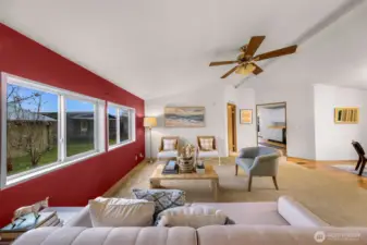 This is a great shot of the living room and you notice the primary bedroom suite doorway at center, the kitchen a slight right and the dining room to your right.