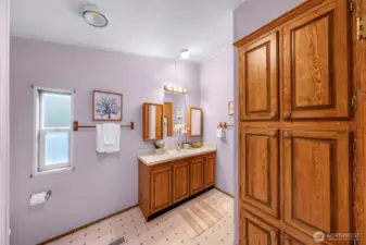 Primary suite full bathroom with plenty of supply closets (don't miss the closet around the far right corner!).