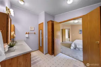 View looking back to the primary bedroom.  The full closet seen where there mirror is, plus storage cabinets by the main doors that swing wide open or can be closed for privacy.