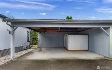 Another view of the carport.  There's a gate that is open in this picture between the home and carport.  It is a latch-type that closes nicely to keep your pup in the fenced yard.  Metal shed included in sale!