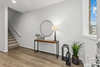 Foyer leading to the garage & stairs up to the upper levels (staged)