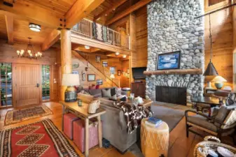 OVERVIEW OF THE FRONT ENTRANCE -GREAT ROOM AND CUSTOM CEDAR STAIRCASE WITH WALKWAY BETWEEN PRIMARY BEDROOM AND 2 OTHER BEDROOMS AND BATH
