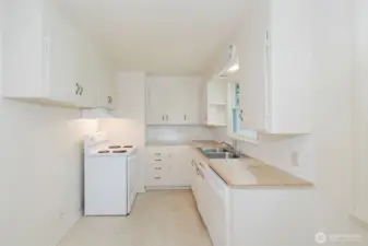 Bright and cheerful, the space features original cabinetry, a classic tile backsplash, and durable laminate countertops.