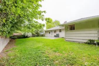 A gently sloped lawn provides ample space for pets, play, or gardening,