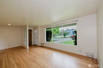 welcoming living room flooded with natural light through a wall of oversized picture windows.