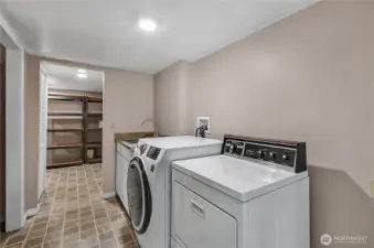 Laundry with a real sink close by! There is lots of storage in this house. Through the doorway the shelves will stay and there is another storage room to the right