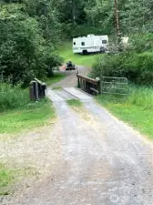 In 8/10 of a mile on a good gravel road after the security gate, you come to a little bridge crossing the Little Mashell River. Do not cross this bridge. The bridge and property with house beyond belong to the neighbor. Park in the area to the left just before the bridge.