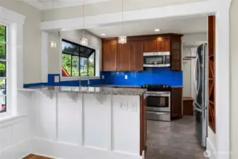 Breakfast bar seating, stainless steel appliances, plus a pot rack add to this amazing kitchen.