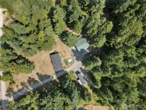 Home, RV parking spots and covered outdoor area surrounded by privacy from mature trees.