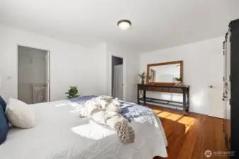 Alternate view of the primary bedroom; bright and filled with light, with bamboo flooring.