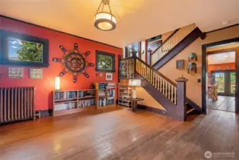 Stunning grand staircase in the entryway with original hardwood floors, classic radiator, and rich period character throughout.
