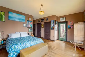 Primary suite features double closets, hardwood floors, private deck access, and a spacious layout with room to spare.