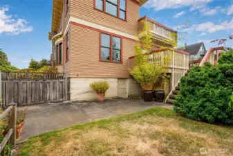 Backyard view showcasing the back deck and stairway, wood fencing, and patio area — great for outdoor entertaining.