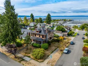 Aerial drone view of the home's large corner lot with sweeping views of the Puget Sound, marina, and Jetty Island just beyond.