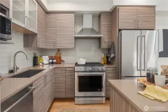 Glass doored cabinets over the undermount sink and an overhead microwave in addition to the gas range.