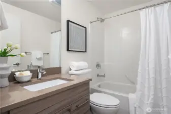 The second floor full bath with designer cabinet, tiled floor and undermount sink.