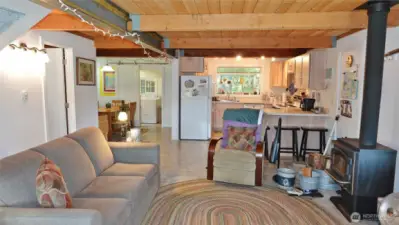 Open Great Room design w/ classic wood ceilings and a wood-burning free-standing fireplace.