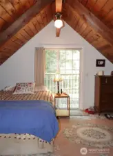 Upstairs 1st Bedroom w/ vaulted wood ceilings.