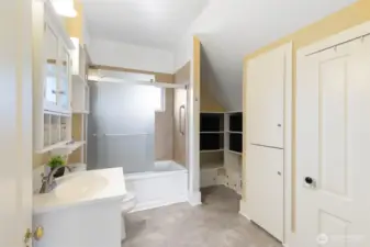 Large bathroom with linen closet and shelving storage.