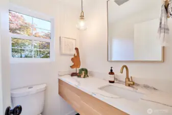 Main floor powder bath with custom floating vanity and plenty of natural light.