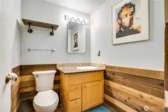 The basement’s 1/2 bathroom exudes rustic flair, blending charming, weathered accents with modern fixtures for a cozy, stylish space that’s perfect for guests.