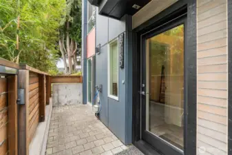 Lower level entrance on east side of building with gate and fence for privacy.