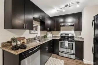 Granite counters, dark cabinets and stainless steel appliances are the highlights of this kitchen.
