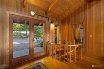 The main entrance to the home and custom-made spiral staircase to the lower level. The laundry room is visible in the back.