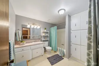 The extra large main bath features loads of linen storage space, a practical tub/shower surround, extra long vanity and even room for a bathroom bench.  Pretty white cabinets too.