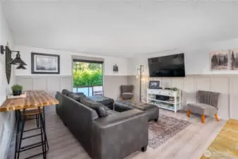 Spacious main-level living room with large picture window bringing in natural light and views of the surrounding greenery.