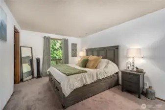 Spacious primary bedroom on upper level with soft natural light, warm wood trim, and ample space for a full bedroom set