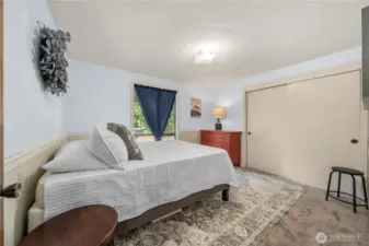 Bedroom 2 on upper level offers a comfortable retreat with soft carpeting, a large window for natural light, and a spacious closet with sliding doors. Neutral tones make it easy to personalize, while the room’s layout provides flexibility for various furniture arrangements.