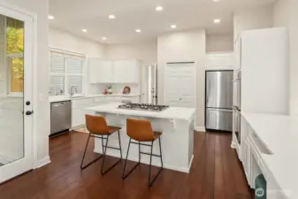 Stainless steel appliances, quartz slab counters, and a freshly painted kitchen.