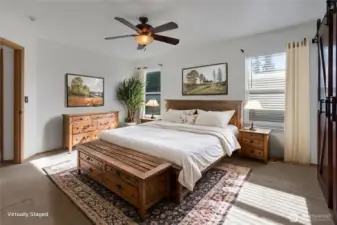 Primary bedroom with ceiling fan, new sliding barn door on the right, to the walk-in closet